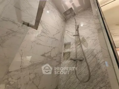 Luxurious marble shower with modern fixtures in elegant bathroom