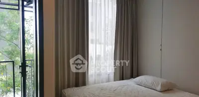 Cozy bedroom with balcony access and natural light, perfect for relaxation.