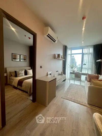 Modern apartment interior with open living room and bedroom, featuring stylish decor and city view.