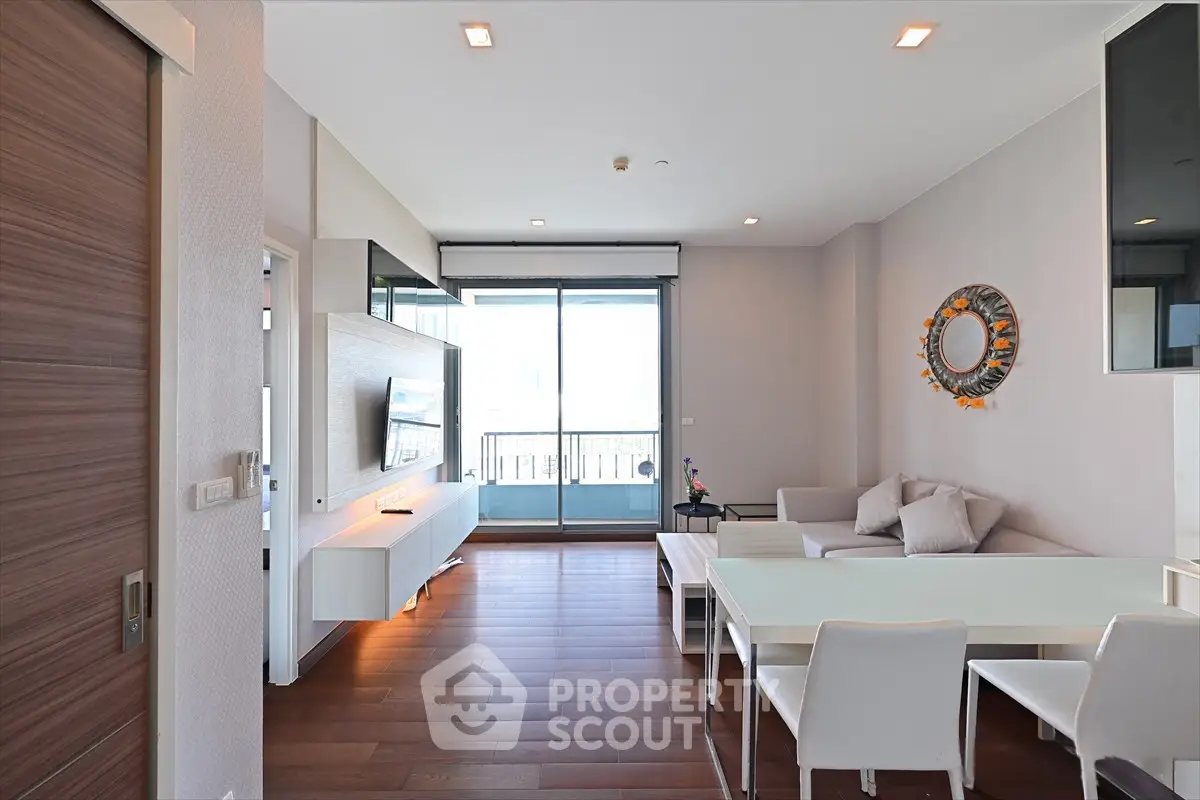 Modern living room with sleek furniture and large balcony access in a stylish apartment.