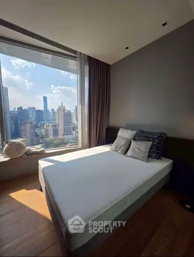 Luxurious bedroom with stunning city view and modern decor in high-rise apartment.