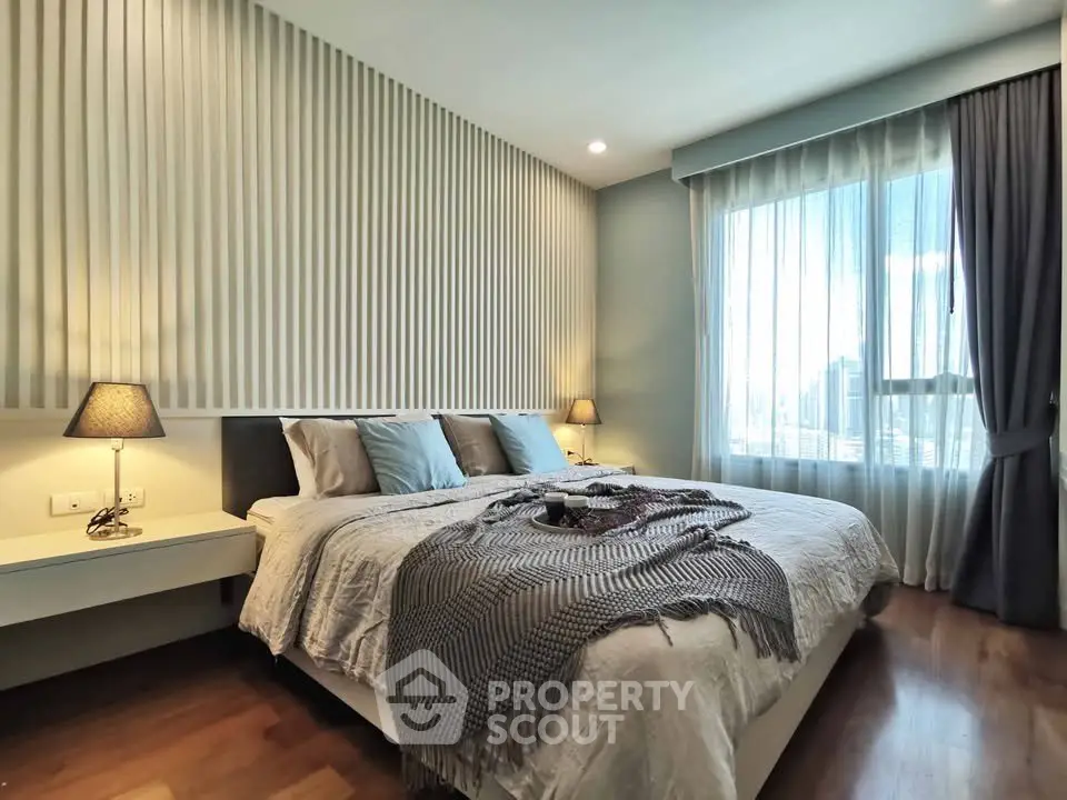 Luxurious bedroom with elegant decor and large window offering natural light