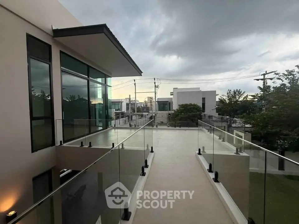 Modern architectural home with glass balcony and sleek exterior design.