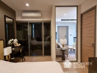 Elegant bedroom with sliding glass doors leading to a cozy balcony, showcasing modern furnishings and a serene atmosphere.