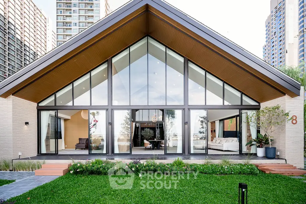 Modern architectural home with large glass facade and lush green lawn