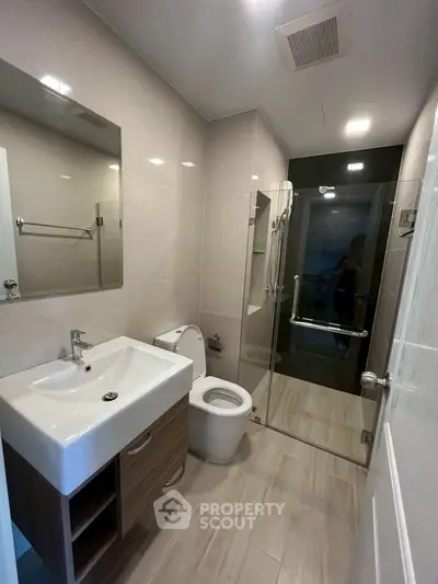 Modern bathroom with sleek fixtures and glass shower enclosure