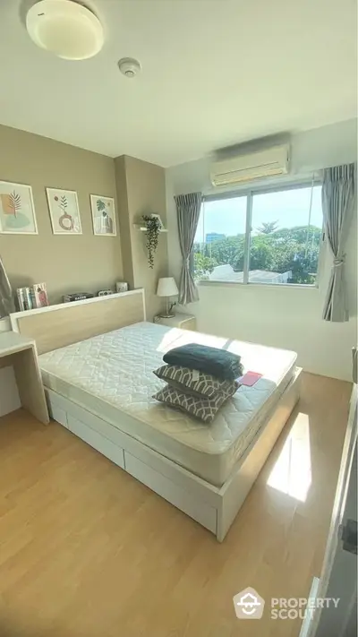 Sunlit spacious bedroom with large windows offering a serene view, complemented by modern furnishings and tasteful decor, perfect for relaxation.