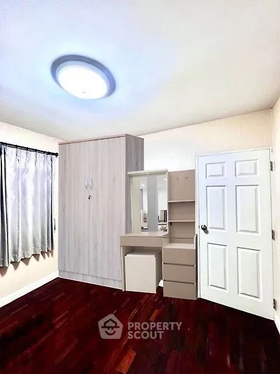Cozy bedroom with wooden flooring and modern wardrobe