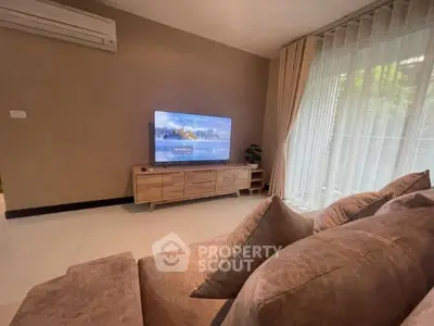 Cozy living room with modern TV setup and plush sofa, perfect for relaxation.