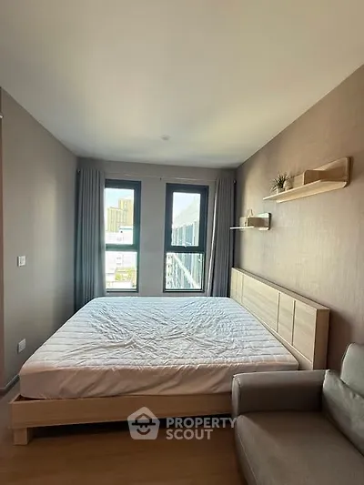 Modern bedroom with large windows and minimalist decor in urban apartment