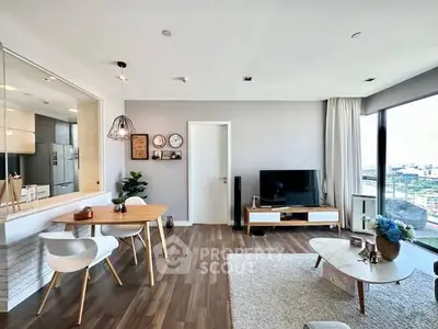 Modern living room with open layout and city view, featuring stylish furniture and decor.