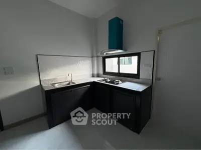 Modern kitchen with sleek black cabinets and gas stove in a compact layout