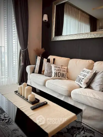 Stylish living room with cozy sofa, decorative pillows, and elegant mirror reflecting natural light.