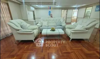 Spacious living room with elegant white sofas and polished wooden flooring