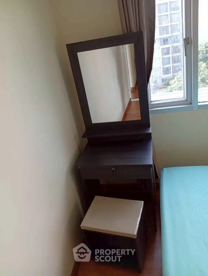 Cozy bedroom corner with a stylish vanity set near a window offering natural light.