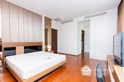 Spacious bedroom with modern wooden paneling, polished hardwood floors, and contemporary furnishings, perfect for urban living.