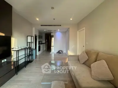 Modern living room with cozy sofa and sleek kitchen in open layout apartment