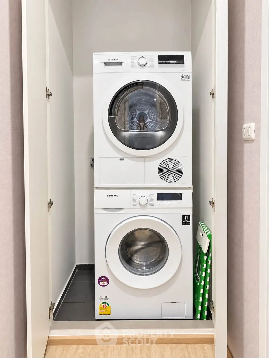 Modern laundry area with stacked washer and dryer in a compact closet space.