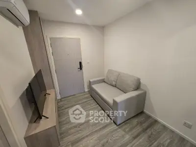 Cozy living room with modern sofa and TV, perfect for relaxation.