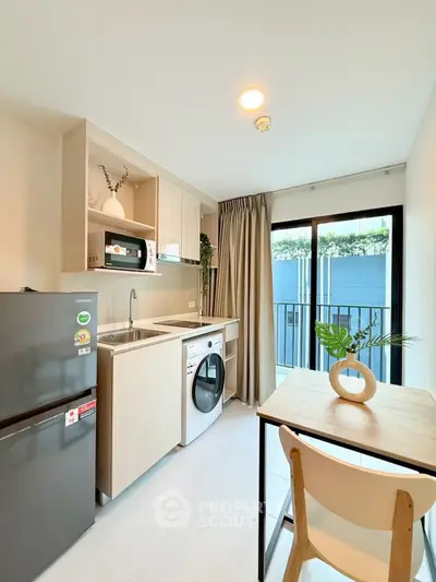 Modern kitchen with washing machine and balcony view in stylish apartment