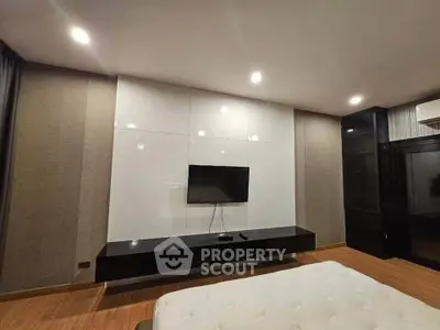 Modern bedroom with sleek TV setup and elegant lighting