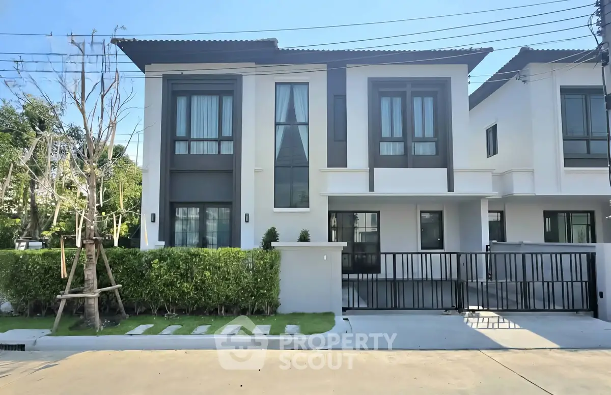 Modern two-story house with sleek design and gated driveway