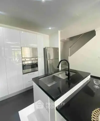 Modern kitchen with sleek black countertops and stainless steel appliances