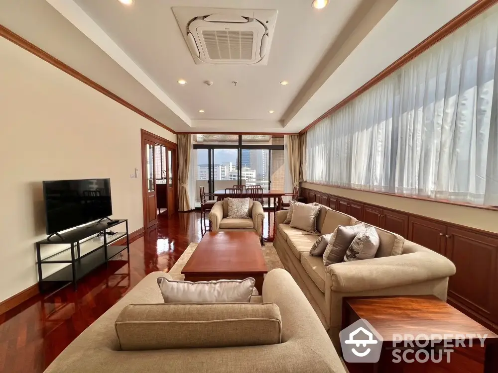 Spacious living room with elegant furniture and city view, perfect for relaxation and entertainment.