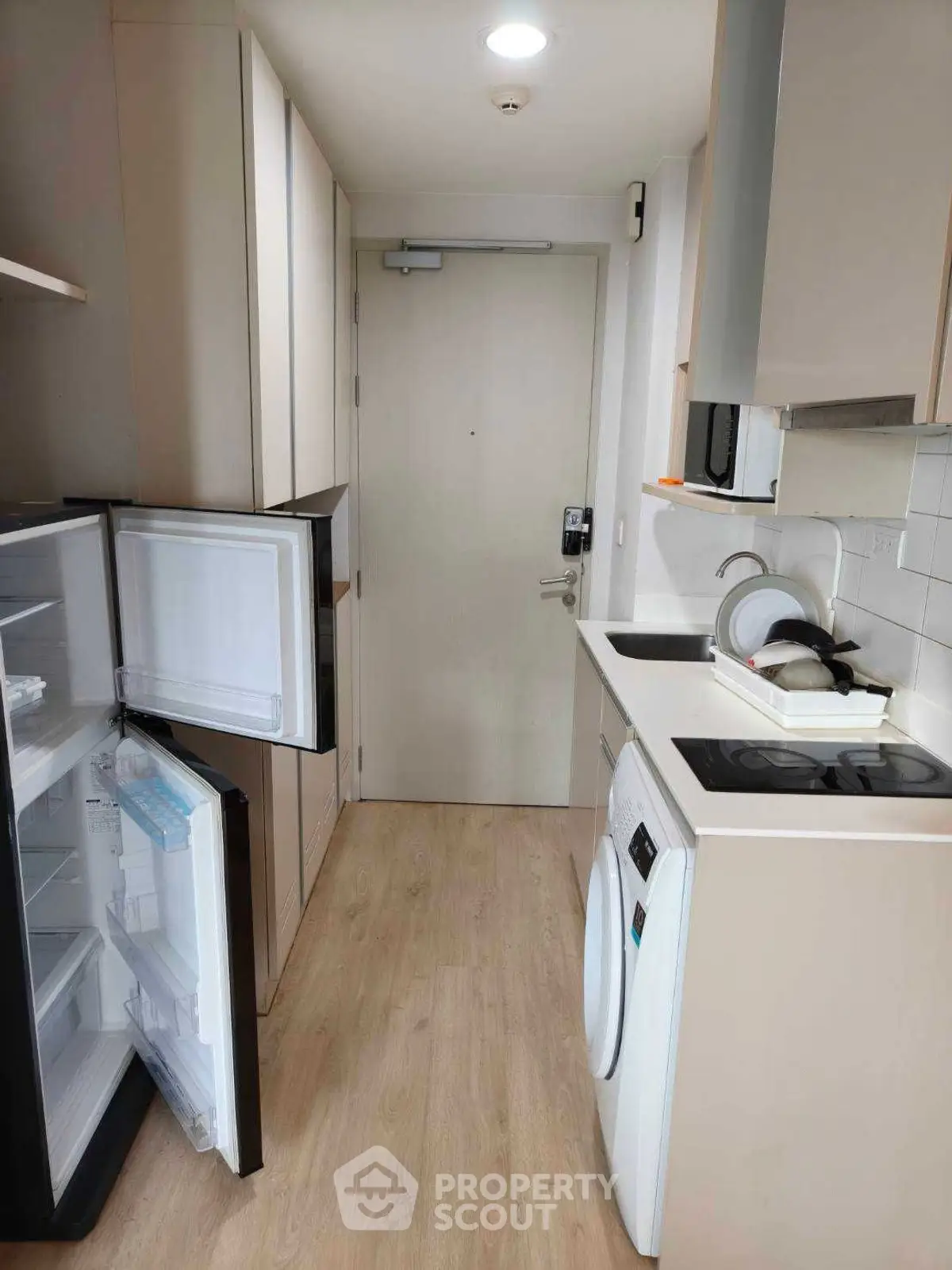 Compact modern kitchen with appliances and wooden flooring