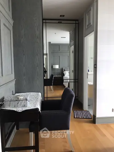 Elegant study nook with plush chair and mirror in modern apartment