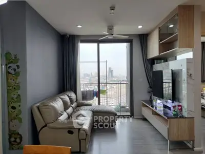 Modern living room with city view, featuring sleek furniture and large windows for natural light.