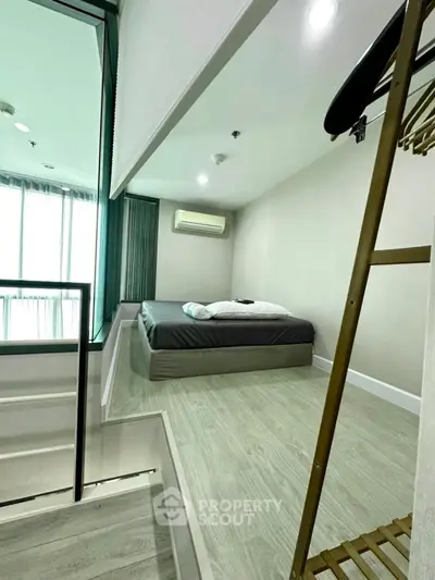 Modern bedroom with minimalist design and large windows for natural light.