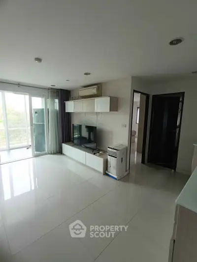 Modern living room with sleek design and natural light, featuring a balcony view.