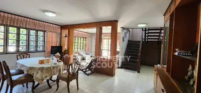 Spacious living room with dining area and staircase in a cozy home