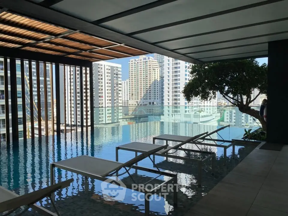 Luxurious rooftop pool with stunning city skyline views and modern lounge chairs.