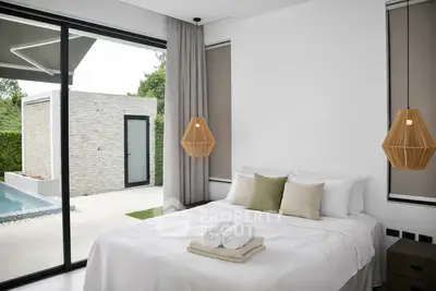Luxurious bedroom with pool view and modern decor in a serene setting.