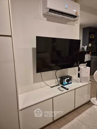 Modern living room with sleek TV setup and air conditioning unit.
