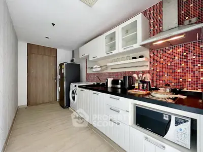 Modern kitchen with sleek appliances and vibrant red mosaic backsplash