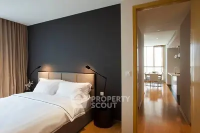 Modern bedroom with elegant decor and view into a stylish kitchen area.