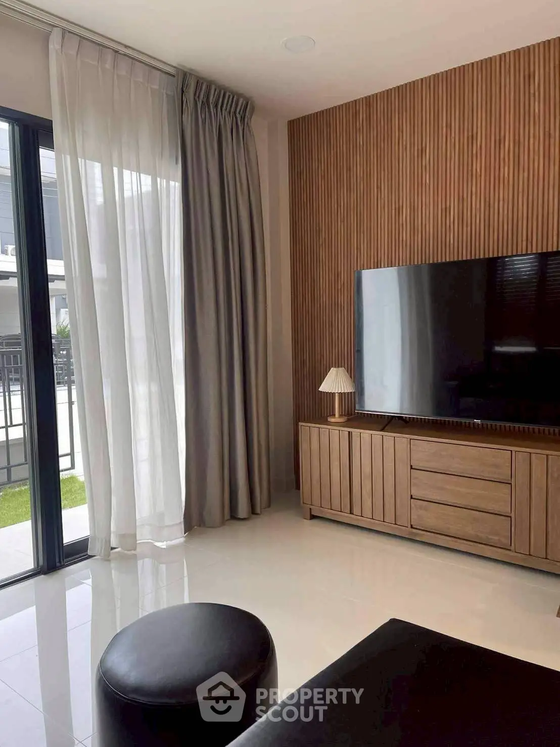 Modern living room with sleek TV setup and stylish wooden paneling