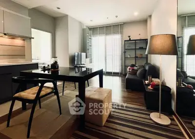 Modern living room with sleek furniture and open layout, featuring a cozy dining area and ample natural light.