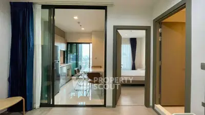 Modern apartment interior with open kitchen and dining area, featuring sleek design and natural light.