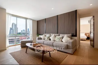 Spacious modern living room with city view, featuring elegant decor and natural light.