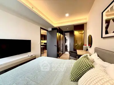 Modern bedroom with stylish decor and open layout leading to kitchen area.