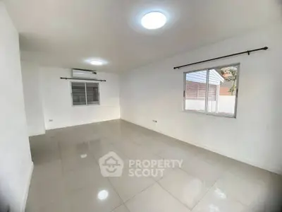 Spacious unfurnished room with tiled flooring and large windows in a modern home.