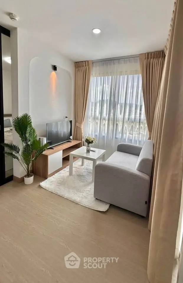 Bright and modern living room with cozy sofa and large window view.