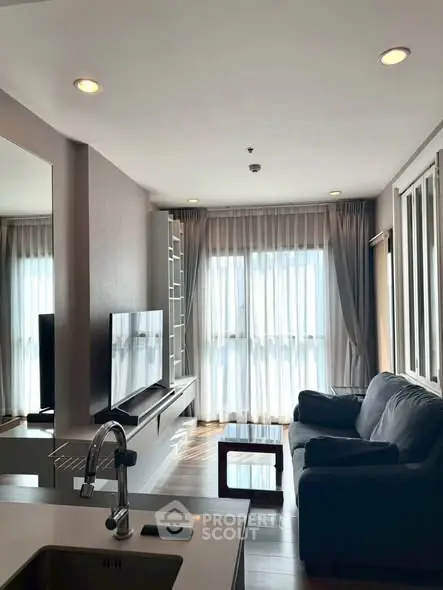 Modern living room with sleek furniture and large windows for natural light.