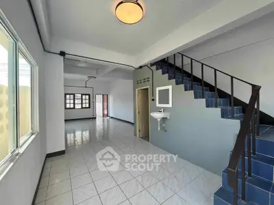 Spacious open-plan living area with modern staircase and ample natural light.