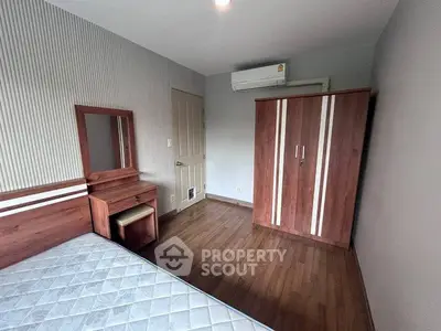 Cozy bedroom with wooden furniture and air conditioning