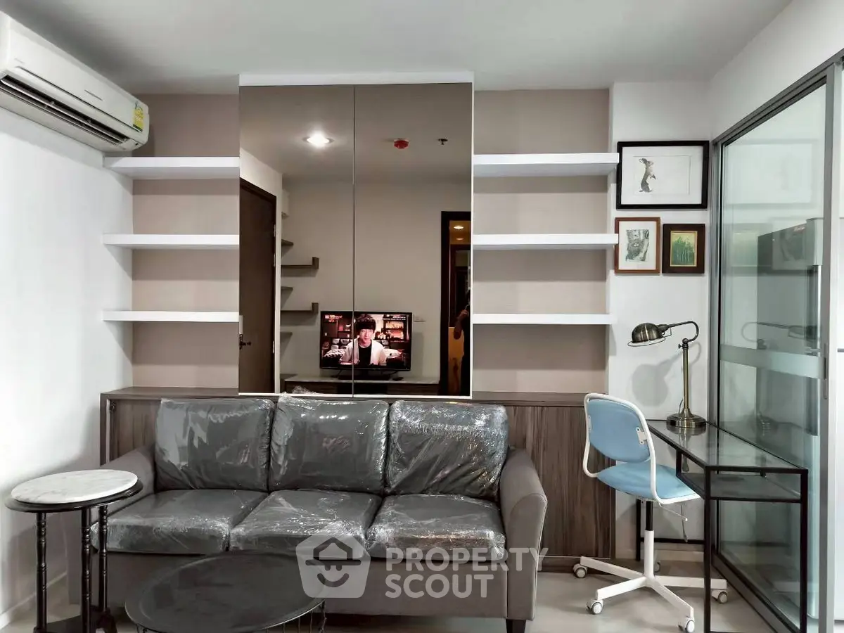 Modern living room with sleek furniture and wall-mounted TV, perfect for urban living.
